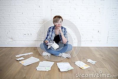 Woman at living room floor with calculator and bank and bills paperwork and documents doing domestic financial accounting Stock Photo