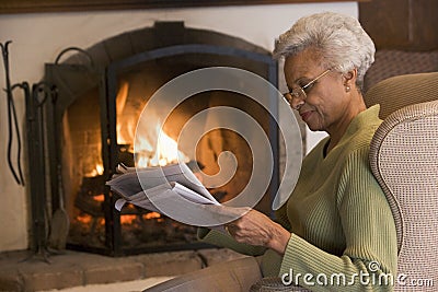 Woman in living room reading newspaper Stock Photo