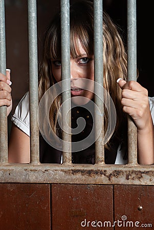 Woman locked in a block looking through the bars Stock Photo