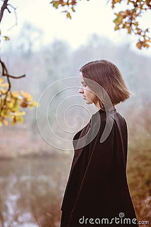 A girl over a cliff above the river, close-up Stock Photo
