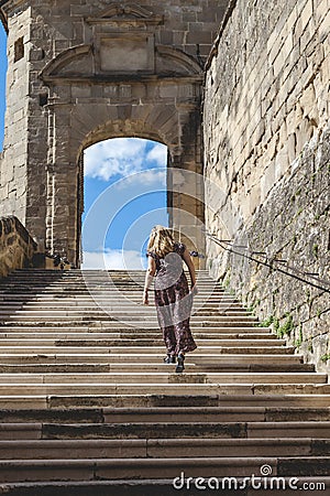 Woman in a long dress is climbing the steps of the abbey of Saint Antoine Editorial Stock Photo