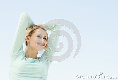 Woman Looking Away With Arms Raised Against Clear Sky Stock Photo