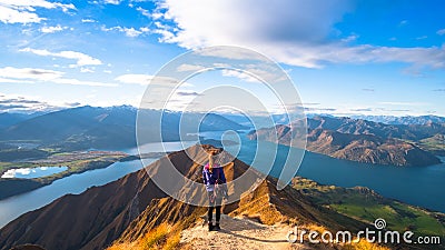 A woman looking at the beautiful landscape of the mountains and Lake Wanaka. Roys Peak Track, South Island, New Zealand. I Editorial Stock Photo