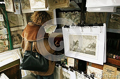 Woman looking at a Book, Bouquinists neer the Seine River in Paris Editorial Stock Photo