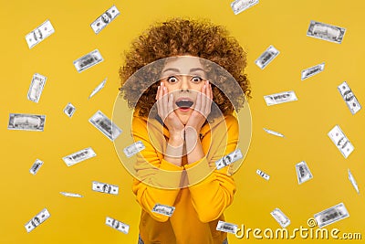 Woman looking at camera with big eyes, absolutely shocked of money rain falling from up. Stock Photo