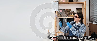 Woman looking at circuit board through magnifying glass. Engineer testing microcircuit though magnifier. Electronic Stock Photo