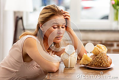 Woman looking at dairy and pastry products having strong allergy Stock Photo