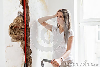 Woman looking at damage after a water pipe leak Stock Photo