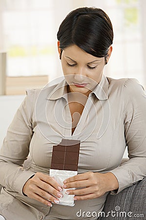 Woman looking guiltily to chocolate Stock Photo