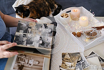 Woman looking through her old photographs 1965-1970, the concept of nostalgia and memories of youth, childhood, remembering her Stock Photo