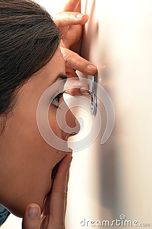 Woman looking out through the peephole Stock Photo