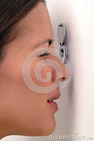 Woman looking out through the peephole Stock Photo