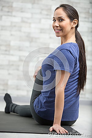 Woman looking over shoulder whilst in yoga twist Stock Photo