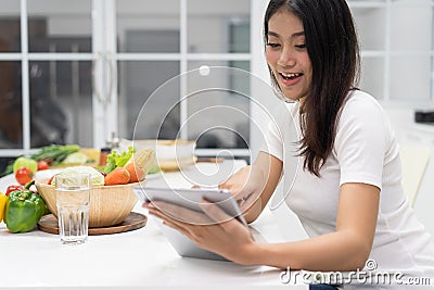 Woman looking for salad diet menu in tablet Stock Photo
