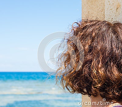 Woman looking at the sea horizon on a beautiful sunny summer day. Useful to indicate concepts of happiness, sadness, amazement, Stock Photo