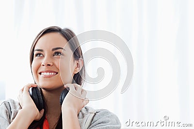 A woman looking slightly upwards and smiling with headphones Stock Photo