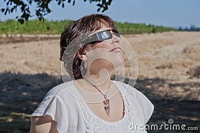 Woman looking at the solar eclipse with eclipse glasses Stock Photo