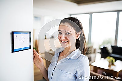 A woman looking at tablet with smart home screen. Stock Photo
