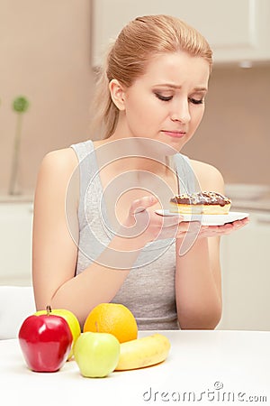 Woman looks at donut and wants to eat it Stock Photo