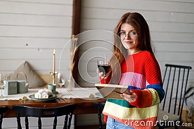 A woman looks at a photograph with a glass of red wine, memories Stock Photo