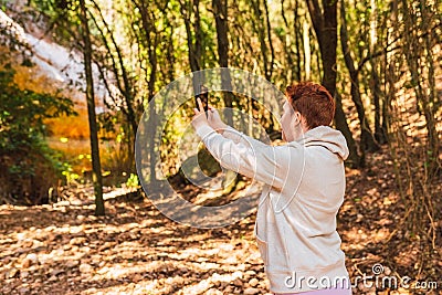 woman lost in the forest, searching for reception signal for her smart phone. accident on vacation. Stock Photo