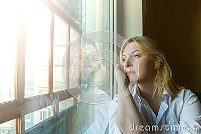 The woman lost in thought looking out the window. Stock Photo