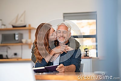 Woman in love kissing senior man on cheeck Stock Photo