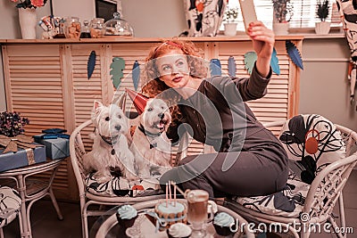 Woman loving her pets making photo with her birthday dogs Stock Photo