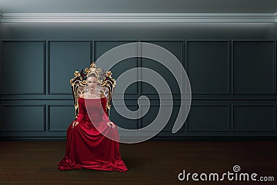 A woman in a luxurious dress sitting on a queen`s throne Stock Photo