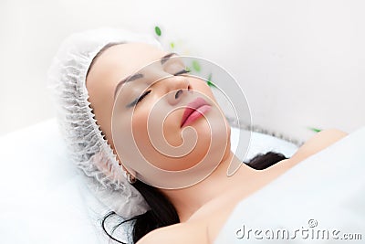 Woman lying on bed while getting beauty injection in neck. Facial treatments. Beauty concept. Stock Photo