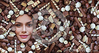 Woman lying on brown chocolate and candies background. Creative chocolate and sweet concept Stock Photo