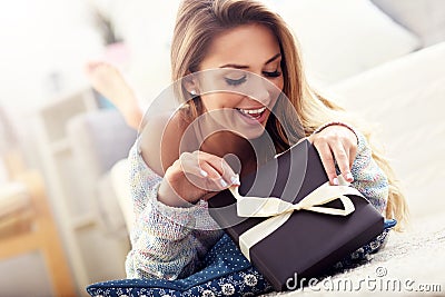 Woman lying on carpet with present Stock Photo