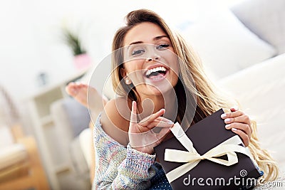 Woman lying on carpet with present Stock Photo