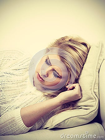 Woman lying on couch feeling very unwell Stock Photo