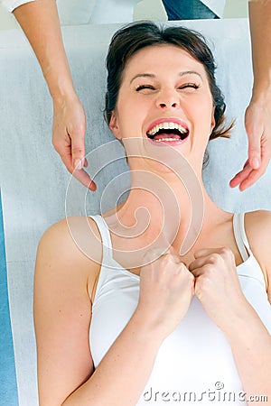 woman lying down smiling and receiving head massa Stock Photo