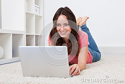 Woman lying on floor in front of laptop Stock Photo