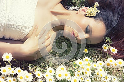 Woman lying on a grass flowers. Closed eyes. Horizontal Stock Photo