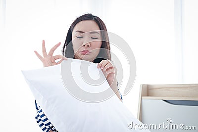 The woman made a foul face. White pillows in the bedroom Stock Photo