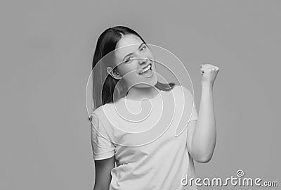 Woman make winner gesture. Portrait of attractive crazy girl breakthrough lucky isolated on gray background. Stock Photo