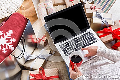 Woman makes christmas shopping online with laptop, above view Stock Photo