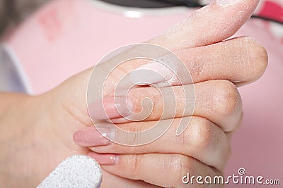A woman makes her own manicure. Removes old nail Polish with a nail buff. Taken in close-up Stock Photo