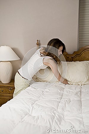 Woman making bed Stock Photo