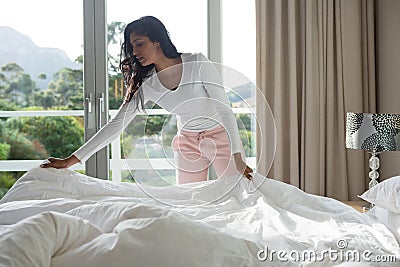 Woman making bed at home Stock Photo