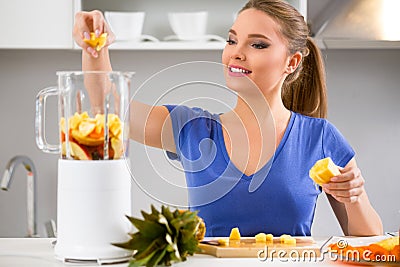 Woman making fruits smoothies with juicer machine Stock Photo