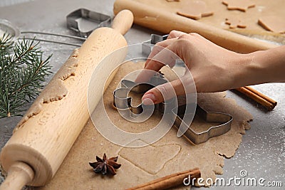 Woman making gingerbread man with cutter at table, closeup. Homemade Christmas biscuits Stock Photo