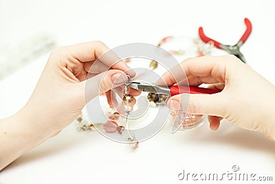 Woman making necklase from colorful plastic beads on light background Stock Photo