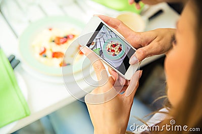 Woman making photo of food on smartphone Stock Photo