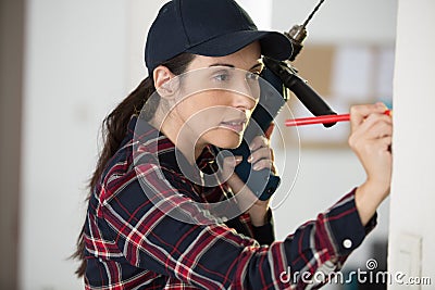 woman making position to drill wall Stock Photo