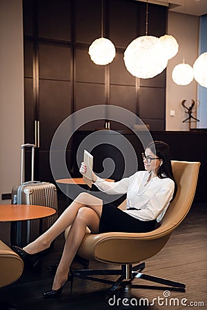 Woman making selfie by tablet in airport waiting room business lounge. Concept of modern technology, communication and Stock Photo