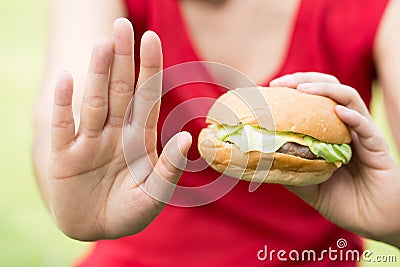 Woman making stop sign with hamburger Stock Photo